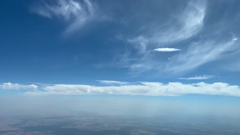 Stunning-pilot-point-of-view-flying-at-cruise-level-with-some-frayed-and-fluffy-white-clouds