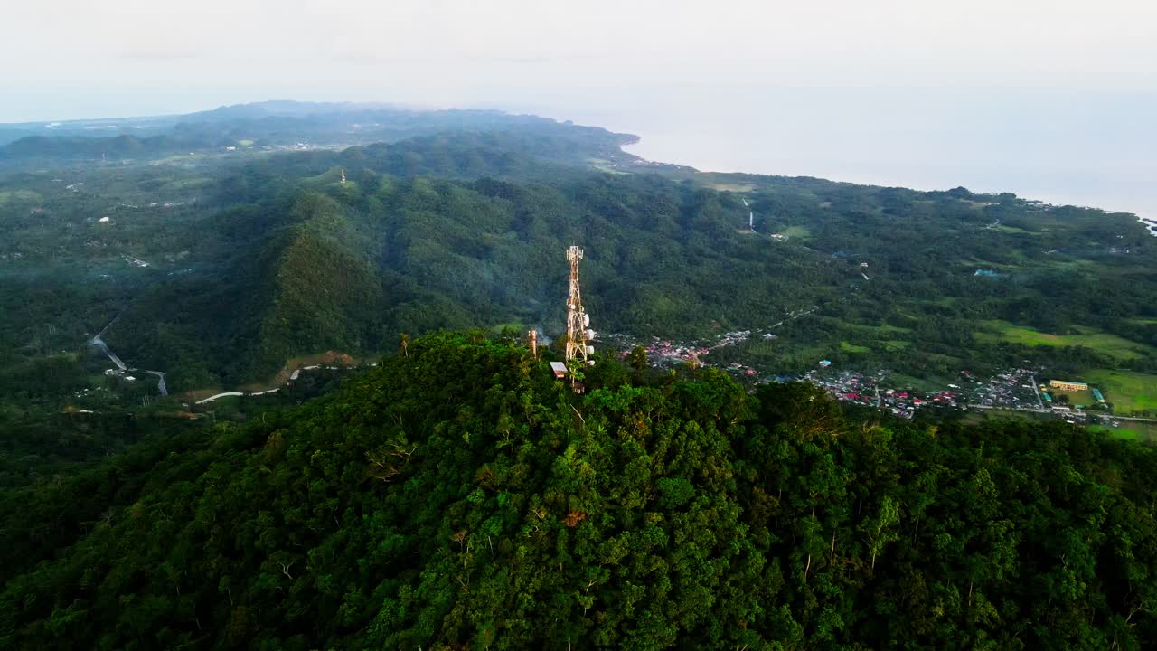 Stunning aerial orbit of a Cell Phone Telecommunications tower atop summit of lush Mount Cagmasuso at San Andres, Catanduanes, Philippines.
