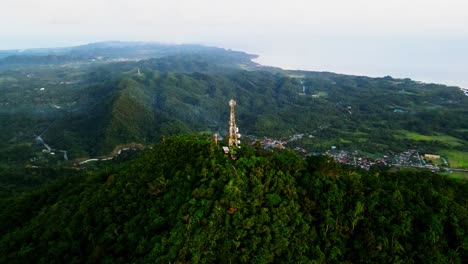 stunning aerial orbit of a cell phone telecommunications tower atop summit of lush mount cagmasuso at san andres, catanduanes, philippines.