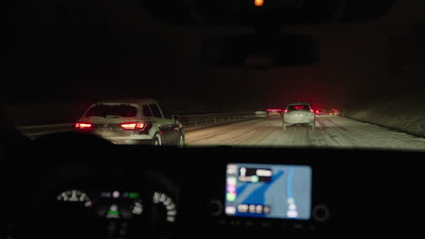 driving on highway during night in snowstorm, heavy traffic on dark road