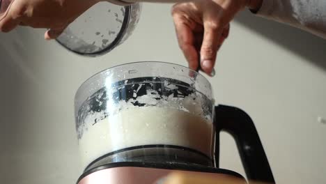 usando un procesador de alimentos para cortar verduras