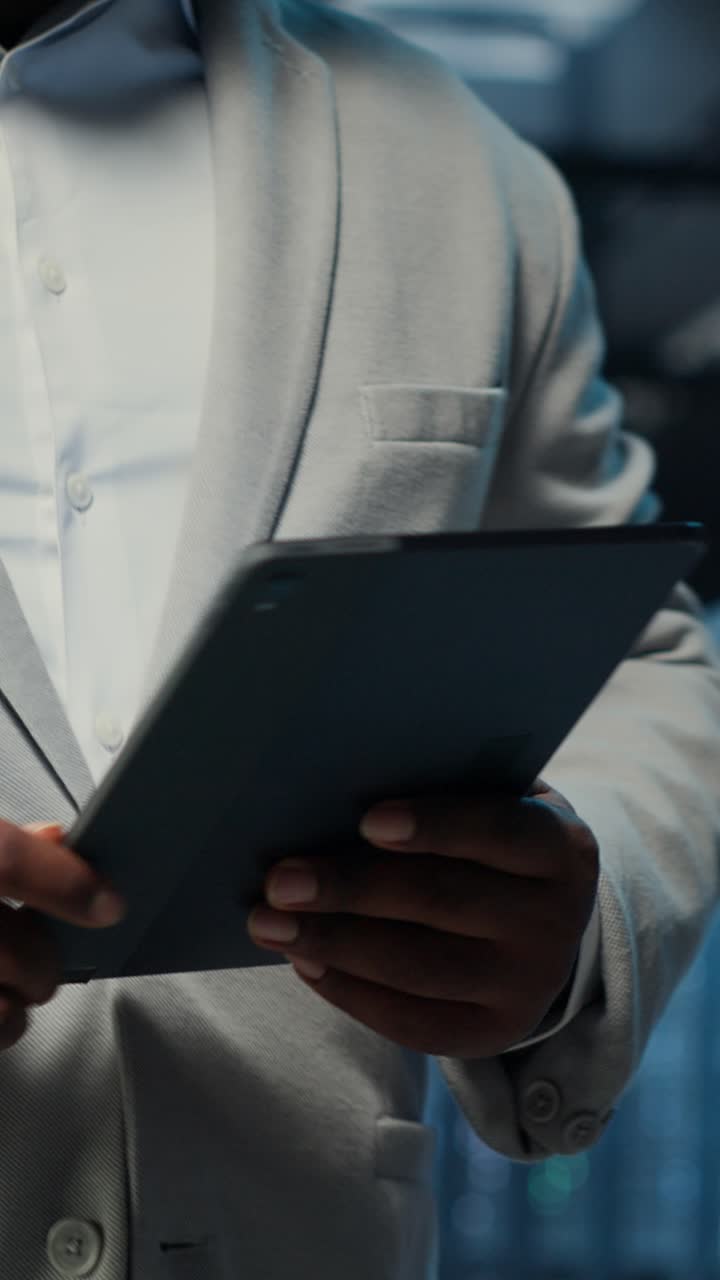 Vertical video Data center system administrator coding on tablet, doing software updates
