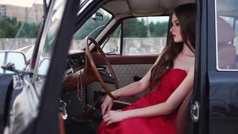 woman in red dress driving a vintage car
