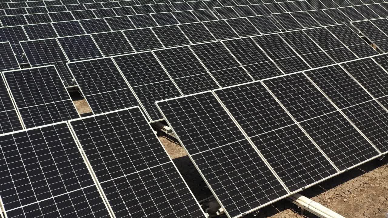 aerial view of solar panels farm photovoltic (PV) solar panels harness sunlight to generate electricity.4k video