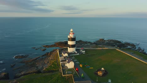 aerial view, sunrise, pan right, hook lighthouse is situated on hook head at the tip of the hook peninsula in co wexford,ireland, oldest lighthouse in the world, was built in the 12th century