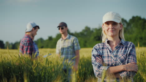 Portrait-Of-A-Female-Farmer-Against-The-Background-Of-Wheat-Fields-And-Other-Farmers