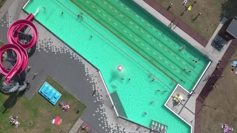 dynamic bird eye view of swimming pool with people having fun 4k