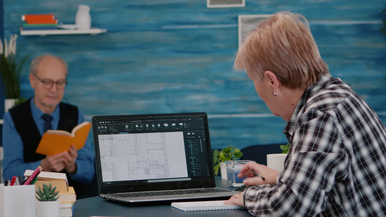 arquitecta sénior analizando prototipo digital con planos desde una computadora portátil