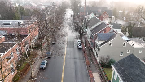 Aerial-flight-in-small-town-during-foggy-winter-morning