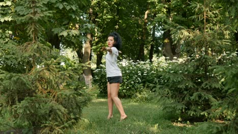 una chica encantadora está dando vueltas y haciendo ejercicios deportivos en el parque