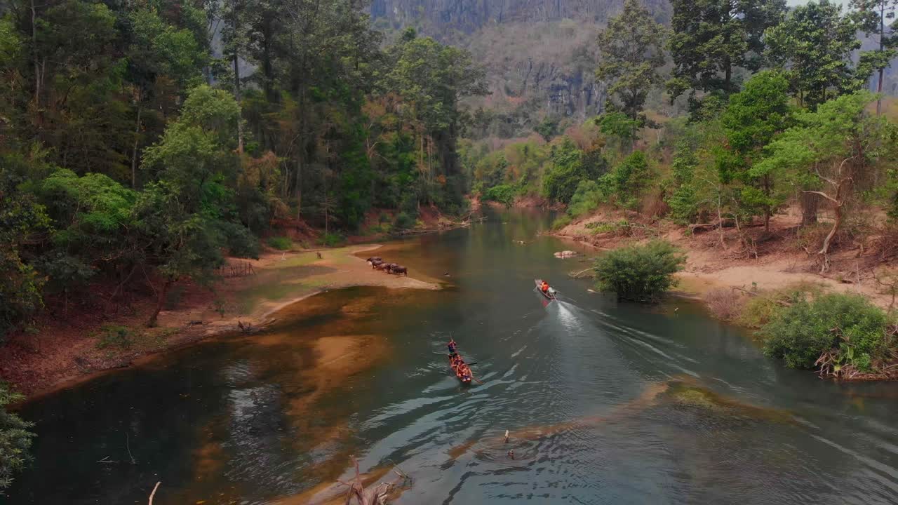Bambini che remano in canoa nel fiume della grotta di Kong Lor. Laos, Khammouane