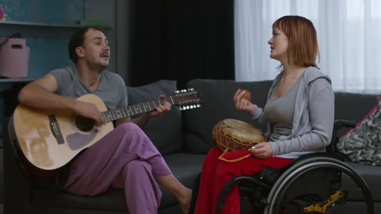 Paraplegic Woman and Cheerful Man Performing Song at Home