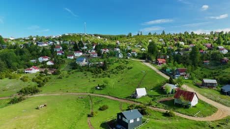 scenic aerial view of rural village by a calm lake under blue sky