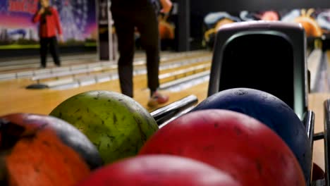 bowling alley scene with colorful bowling balls and people