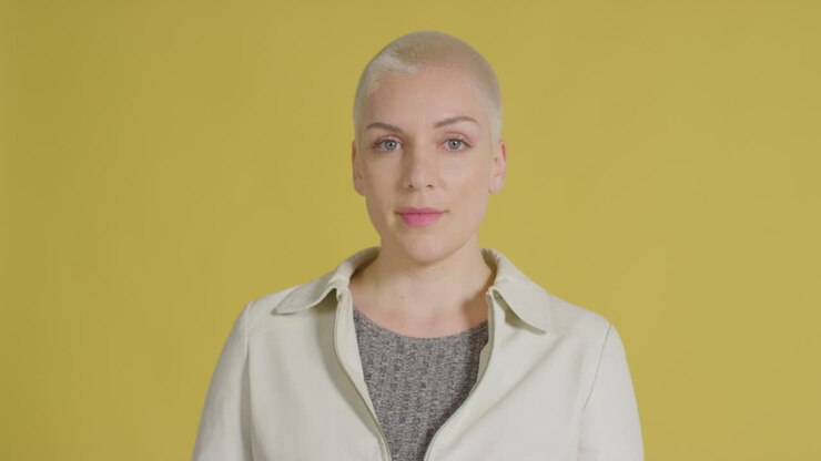 Female caucasian model posing for studio portrait with yellow backdrop 01