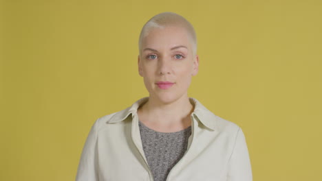 female caucasian model posing for studio portrait with yellow backdrop 01