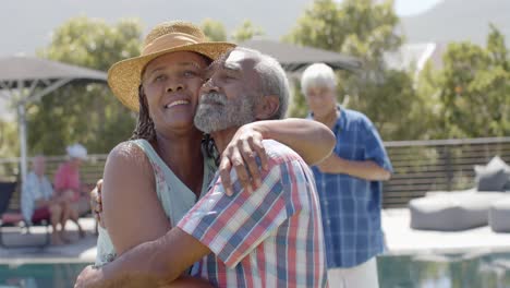 Portrait-of-happy-diverse-senior-friends-embracing-at-sunny-garden-party,-unaltered,-in-slow-motion