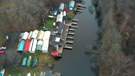 tiny ramshackle sheds laying beside a tiny inlet surrounded by forest