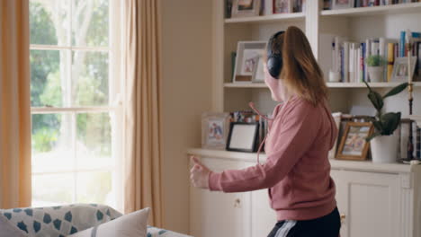 Una-Adolescente-Genial-Bailando-Con-Audífonos-Escuchando-Música-Divirtiéndose-Adolescente-Celebrando-Con-Movimientos-De-Baile-Locos-En-Casa-Disfrutando-De-La-Libertad-El-Fin-De-Semana-4k