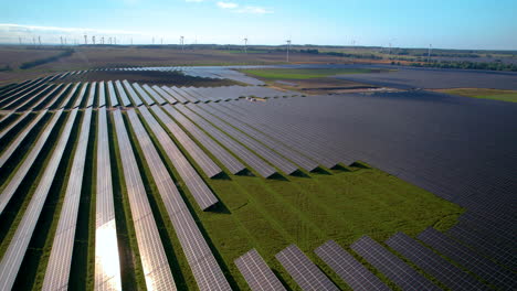 背景有風力輪的龐大太陽能發電廠的空中景觀