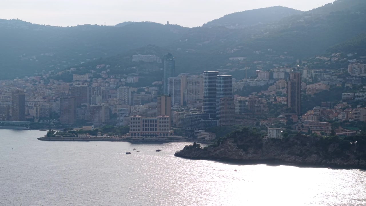 Drone riprende lo skyline di Monaco e l'Hotel Monte-Carlo Bay sopra il mare illuminato dal sole