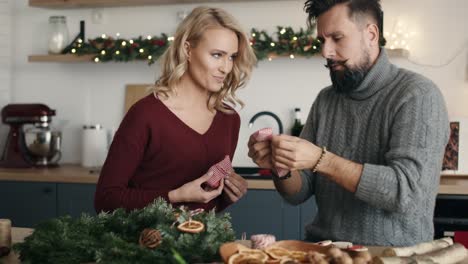 pareja adulta haciendo decoraciones de navidad juntos