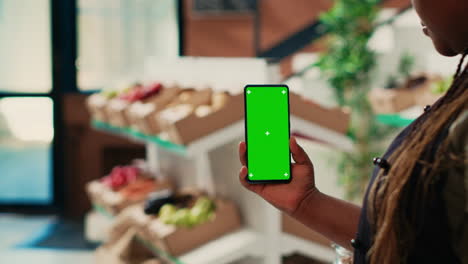 comerciante con un teléfono inteligente con pantalla verde