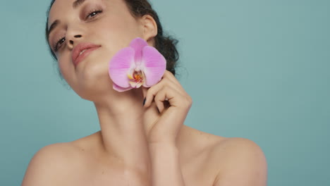 beauty portrait beautiful woman touching body with colorful pink orchid flower caressing smooth healthy skin complexion enjoying fresh natural fragrance skincare concept