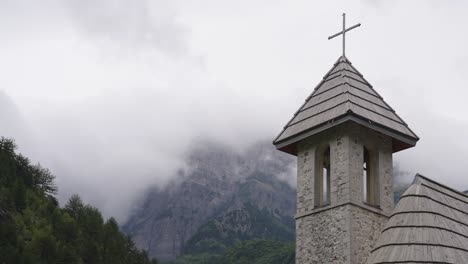 church of theth tower with misty mountains in background - albania