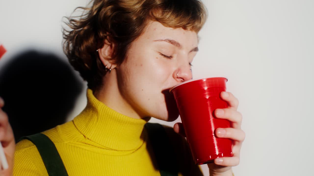 mujer celebrando con una copa roja y una bandera americana