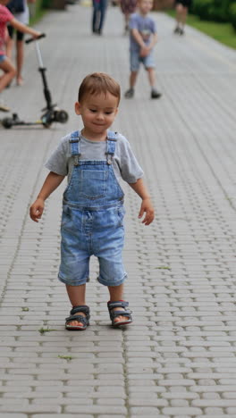 little boy playing outdoor in park. spring vacation park child. vertical video