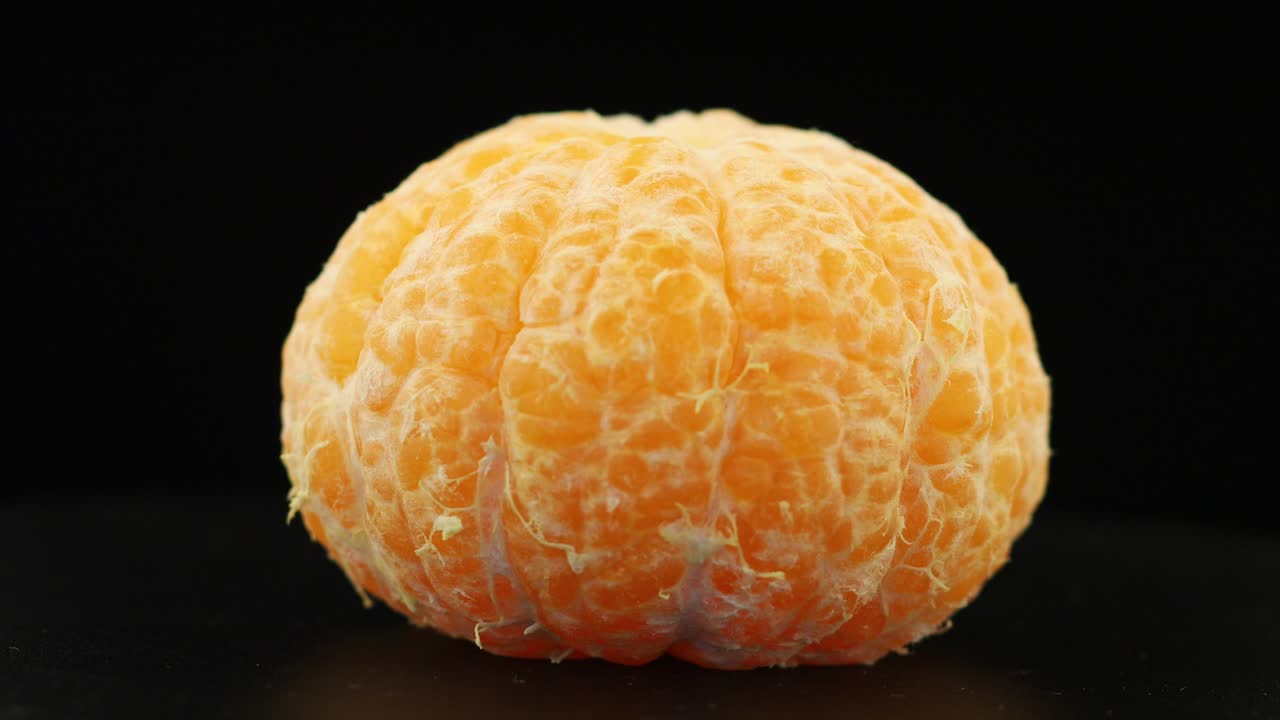 Peeled tangerine without peel spinning close-up