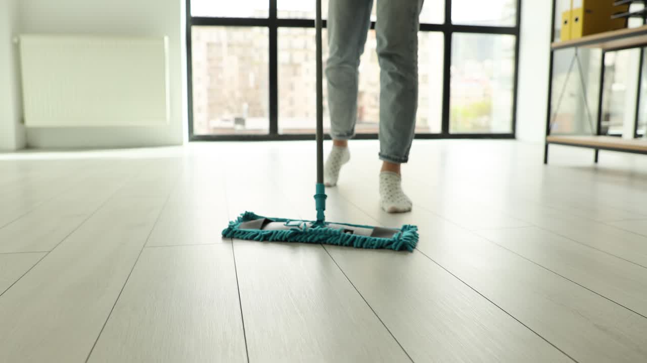 Person mopping a light-colored floor