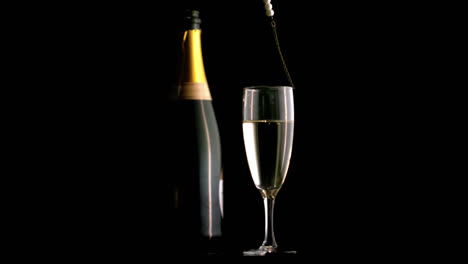 Grey-paper-burning-and-confetti-falling-over-pearl-beads-falling-in-champagne-glass