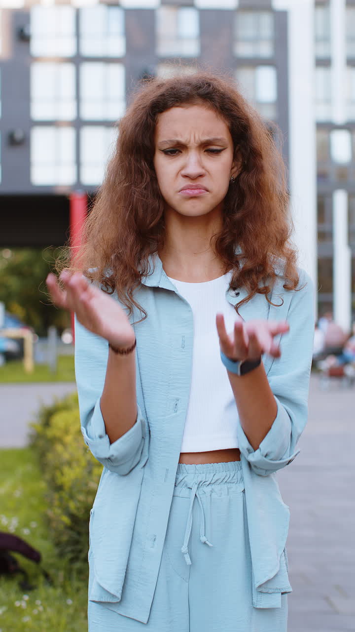 Surprised frustrated teen child girl raising hands asking reason of failure demonstrating disbelief