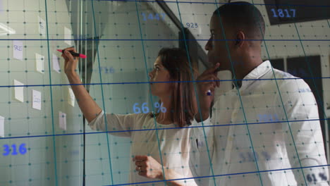 somos un grupo diverso de hombres de negocios escribiendo en una pizarra en una oficina moderna.