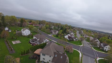 Fpv-drone-shot-of-single-Family-houses-on-road-in-american-suburb-with-driving-car