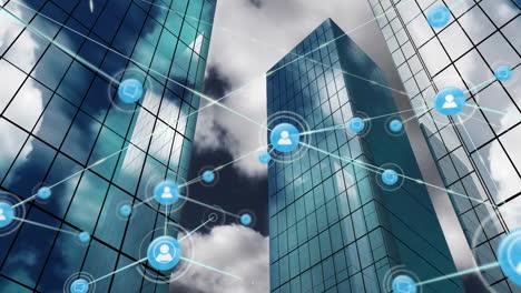 animation of network of digital icons against low angle view of tall buildings and blue sky