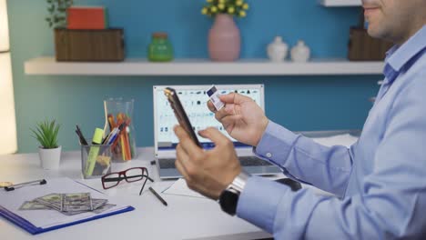 hombre comprando productos por teléfono con una tarjeta de crédito.