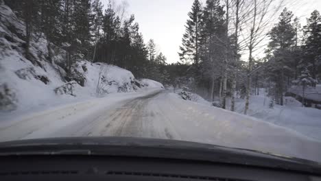 Toma-Pov-De-Un-Automóvil-Que-Conduce-A-Través-De-Una-Carretera-De-Montaña-Nevada-Durante-El-Invierno