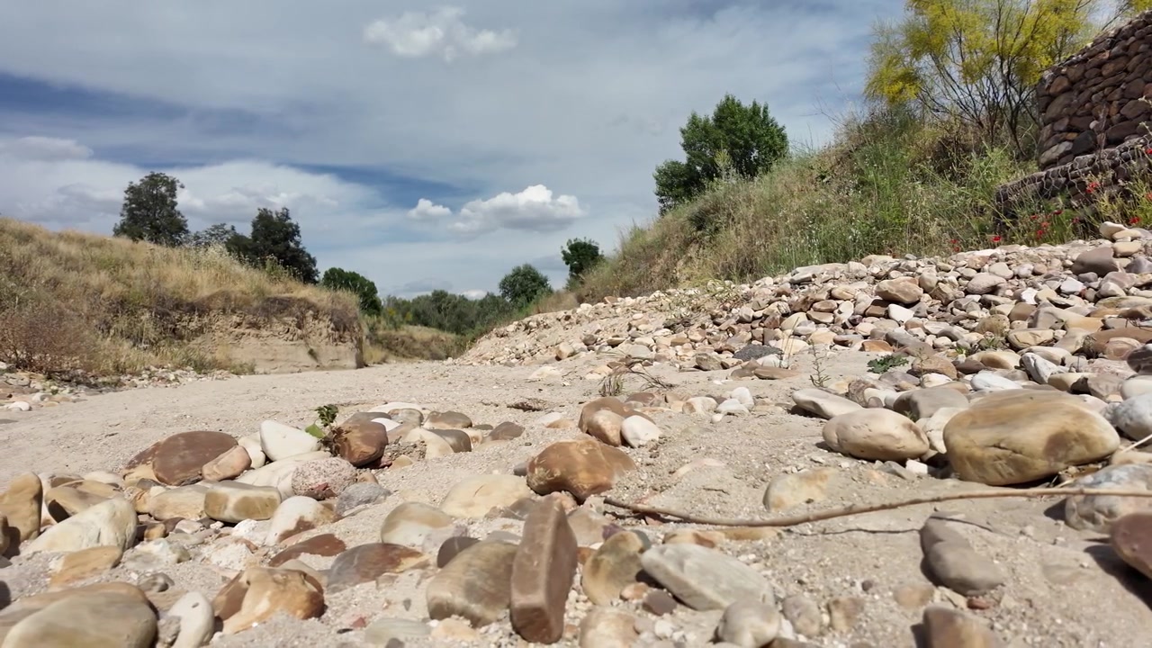 Ripresa al rallentatore di un letto di fiume asciutto durante una grave siccità estiva in Francia.