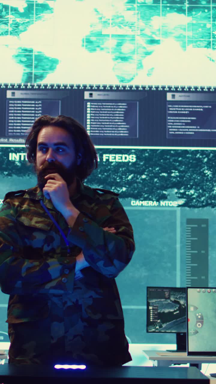 Bearded Man in Camouflage Jacket Talking in High-Tech Control Room