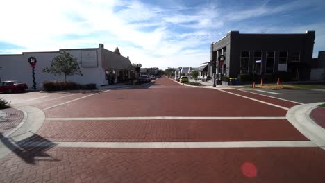 Wide-angle-dolly-establishes-historic-red-brick-road-of-Downtown-Clermont-Florida-at-midday