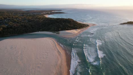 Sunrise-over-waves-crashing-on-the-beach-at-Lake-Conjola,-Australia