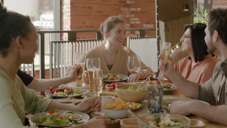 mujer joven pasando un buen rato con su grupo multicultural de amigos en una cena