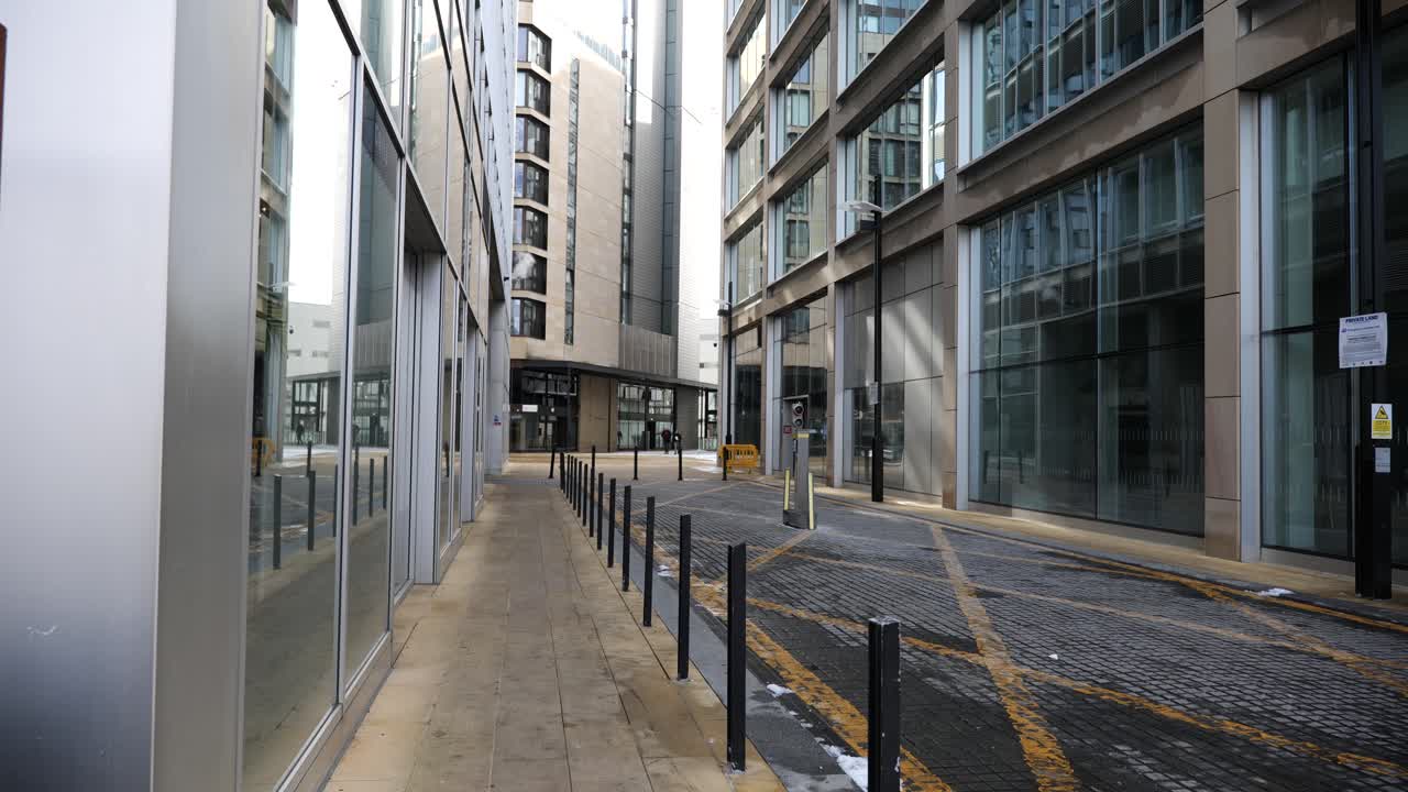 A city centre side street with impressive, glass fronted office buildings in an industrial setting