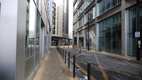 Una-Calle-Lateral-Del-Centro-De-La-Ciudad-Con-Impresionantes-Edificios-De-Oficinas-Con-Fachada-De-Vidrio-En-Un-Entorno-Industrial