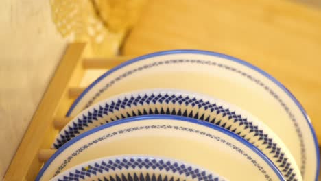 stacked blue and white dishes on a wooden rack