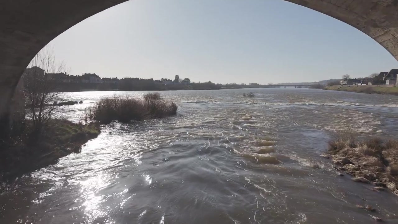 砂浜近くのロワール川で、さざ波立つ水面に太陽の光がきらめく空撮。
