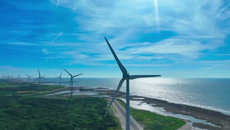 row of wind turbines rotating during windy day on coast of taiwan